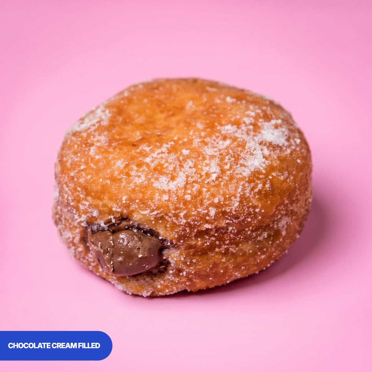 Gluten free vegan fried sugared doughnut filled with chocolate cream, the filling visible at the side