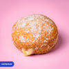 Gluten free oat free vegan fried sugared doughnut filled with vanilla custard, the filling visible at the side
